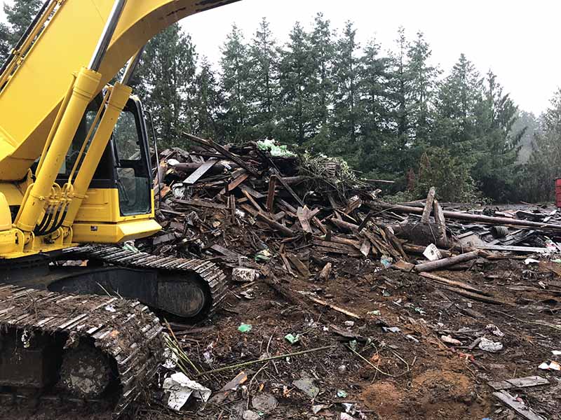 An excavator clearing debris on a demolition job site